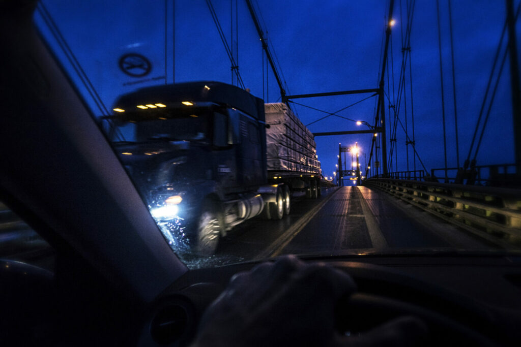Auto qui croise un camion, la nuit, sur le pont Ambassador.
