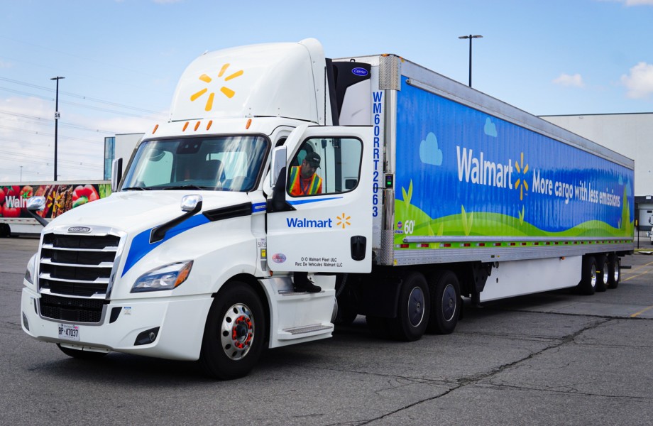 Vue de face d’un camion et remorque réfrigérée Walmart au quai de chargement avec chauffeur qui en descend.
