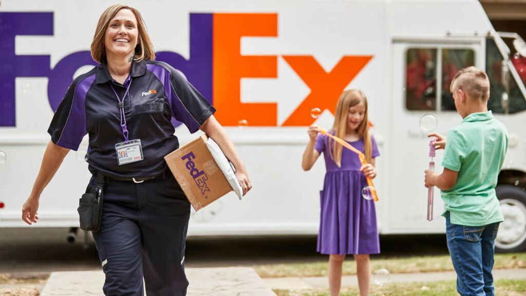 Femme transporte un colis avec enfants et camion FedEx en arrière-plan