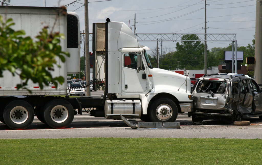 Camion blanc avec remorque emboutit une minifourgonnette à une intersection