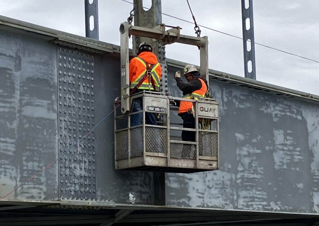 Travailleurs dans une nacelle inspectent le pont Touzel