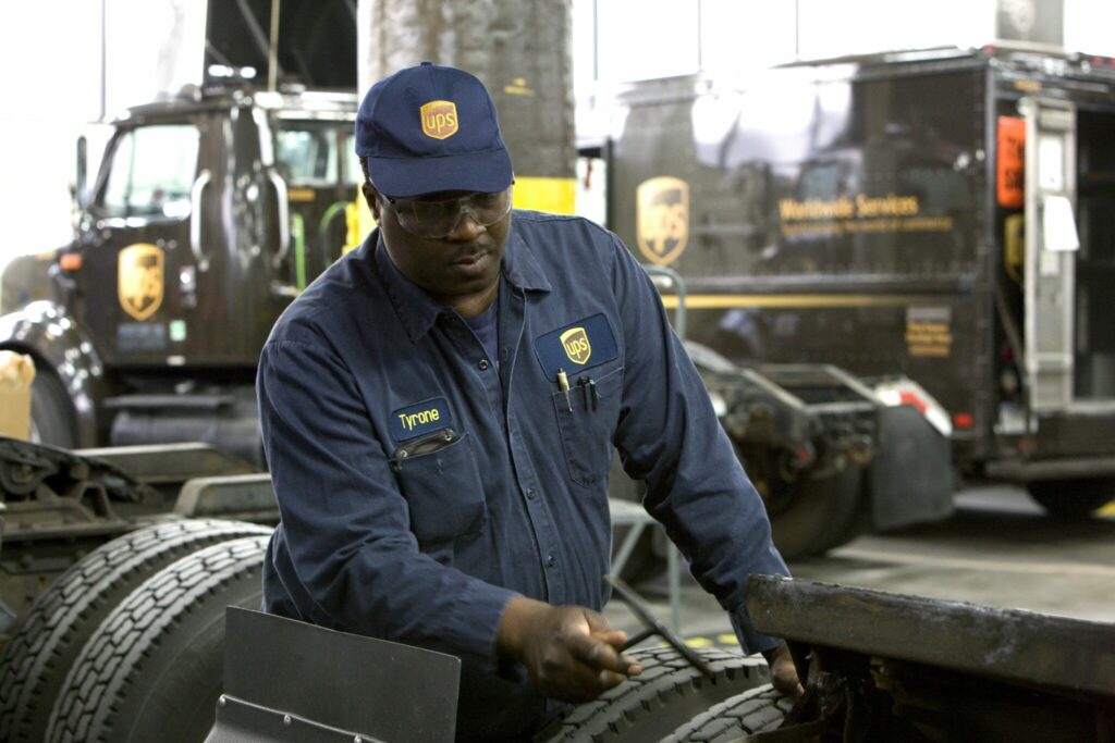 Employé d’UPS vérifie les pneus d’un camion