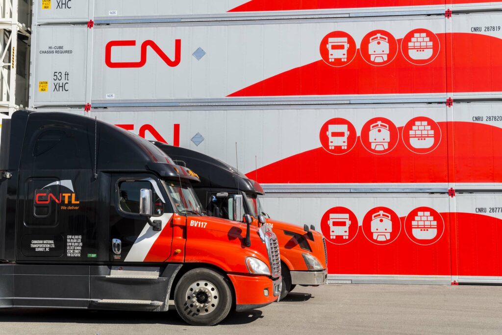 Camions du CNTL devant des conteneurs intermodaux