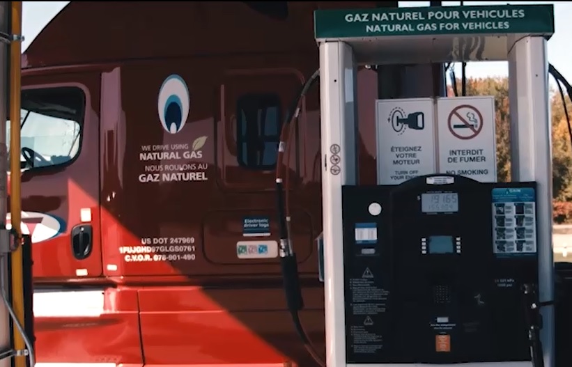 Camion C.A.T. vu de côté à un poste de remplissage de gaz naturel