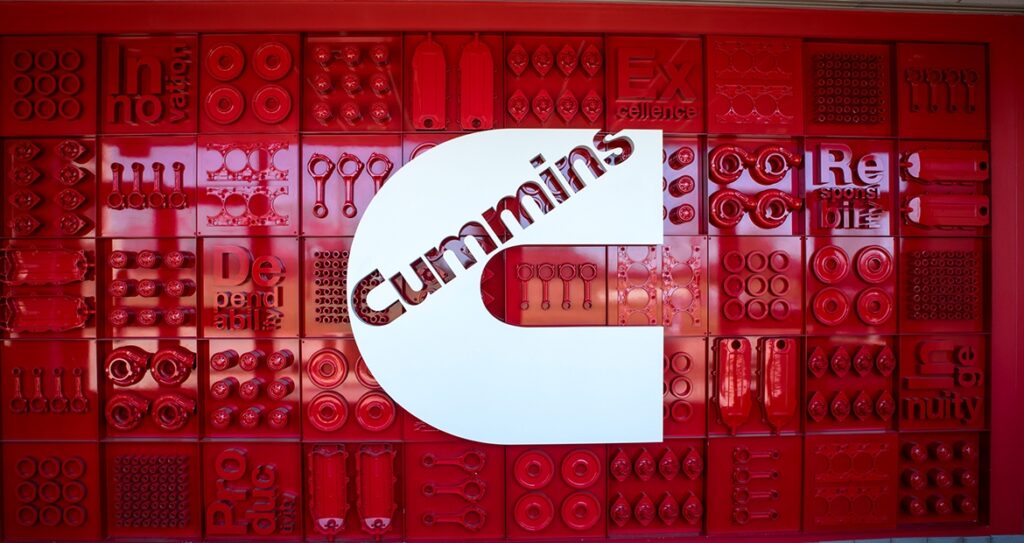 Logo Cummins sur fond de composantes mécaniques