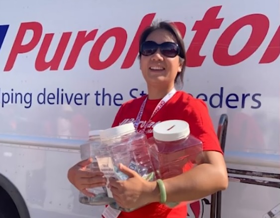 Femme tient des bocaux de cueillette d’argent devant un camion Purolator