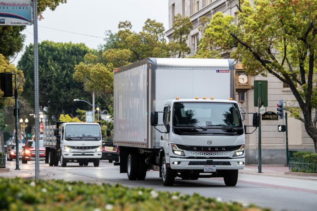 2 camions électriques Rizon l’un derrière l’autre en circulation urbaine.